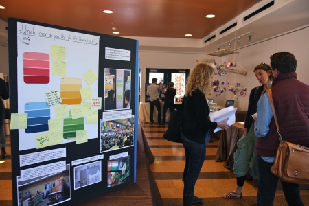 Teachers from various OLC schools discuss the array student work on display, including a library redesign project (left) at OIHS. Photo by Emi Kane.